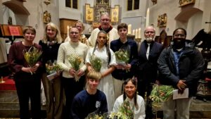 Volwassenen staan bij het altaar om doop en Vormsel te ontvangen